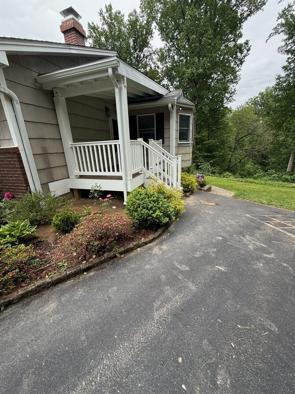Home exterior with a covered front porch and fresh landscaping by R.A. Homes